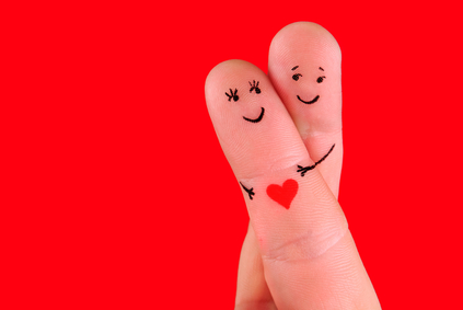 happy couple concept - a man and a woman hug,painted at fingers isolated on red background
